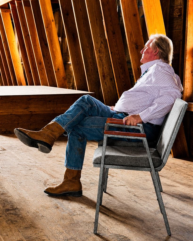 John Zelbst listening from a chair in the barn
